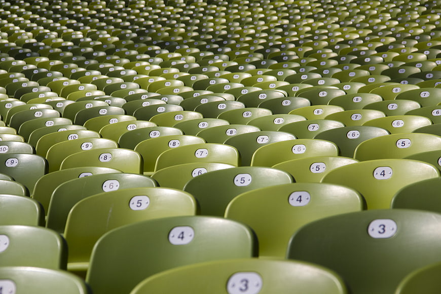 Rows of Empty Green Auditorium Seats with Numbers