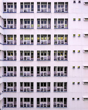 Symmetrical facade of a white apartment building with repeating windows