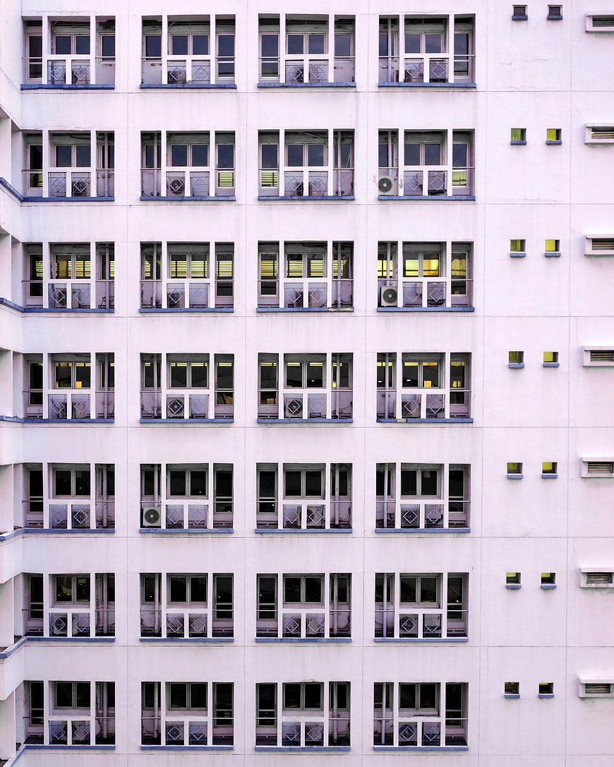 Symmetrical facade of a white apartment building with repeating windows