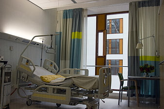 Empty modern hospital room with bed and window