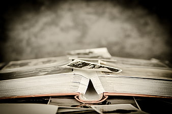 Vintage photo album with scattered old black and white pictures