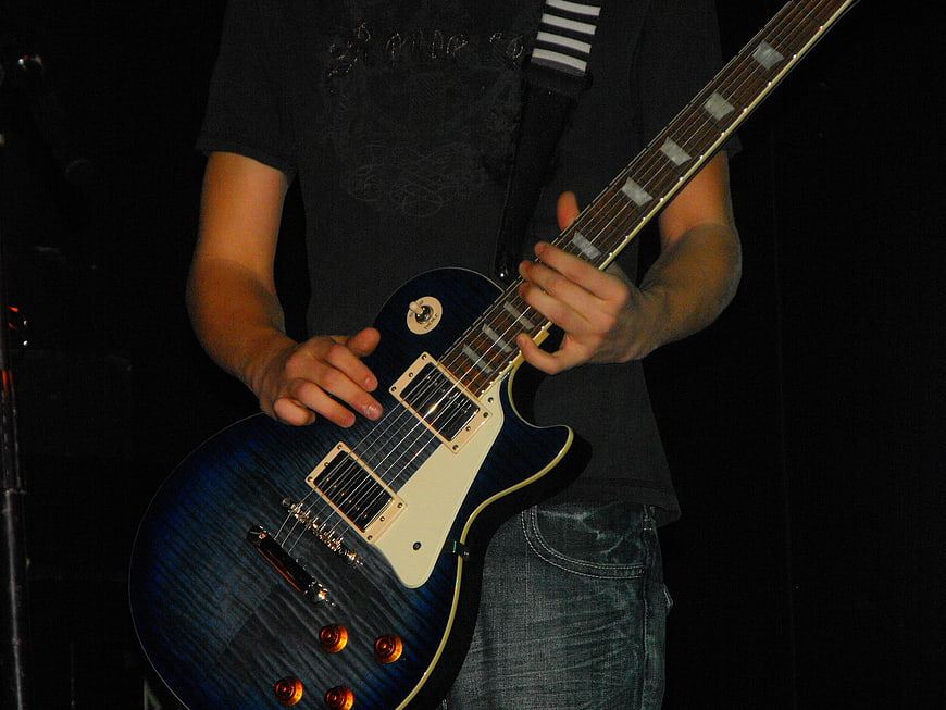 Guitarist Playing Blue Electric Guitar On Stage