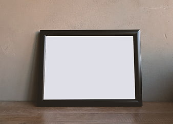 Empty black picture frame mockup on wooden shelf