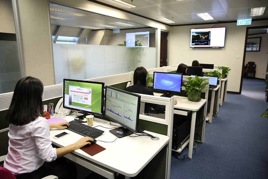 Financial analysts working in modern office with stock charts