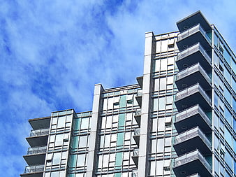 Modern Apartment Building with Balconies Against Blue Sky