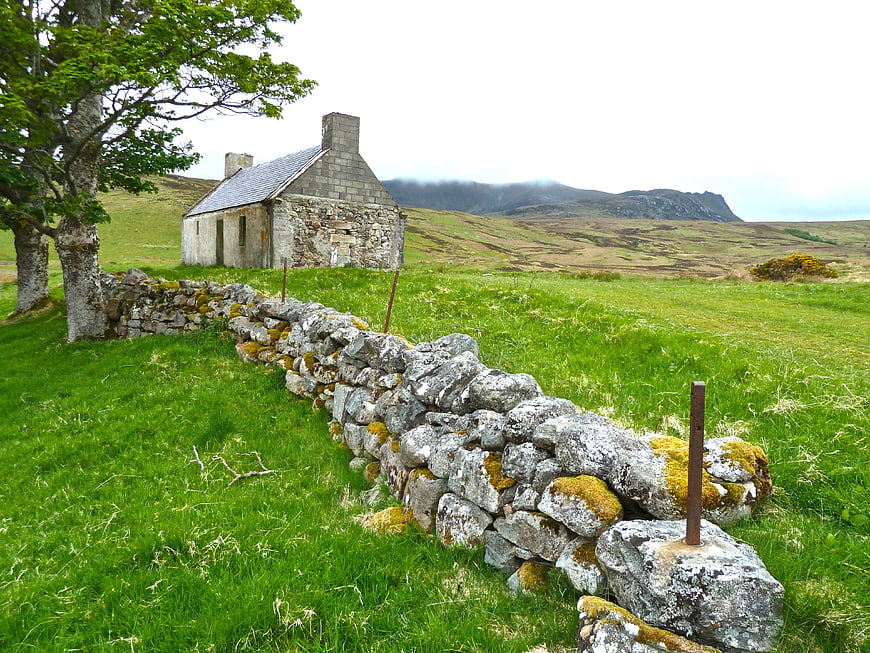 Old stone cottage in green Irish countryside landscape
