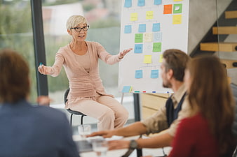 Senior female business leader presenting strategy to team