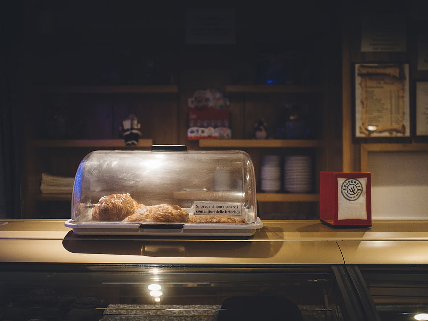 Croissants in a bakery display case with warm lighting