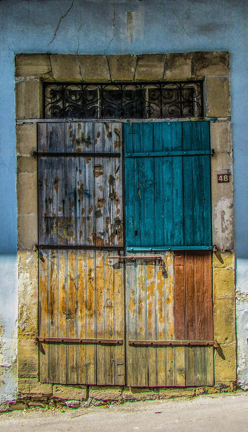 Weathered Wooden Door with Blue Shutters and Stone Frame