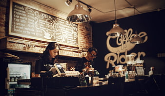 Baristas working in a rustic coffee shop interior