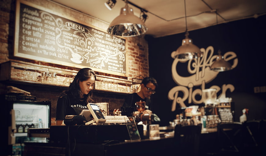Baristas working in a rustic coffee shop interior