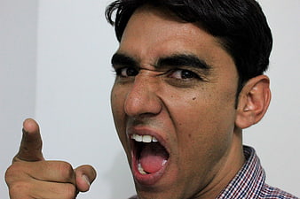 Angry man shouting and pointing finger aggressively