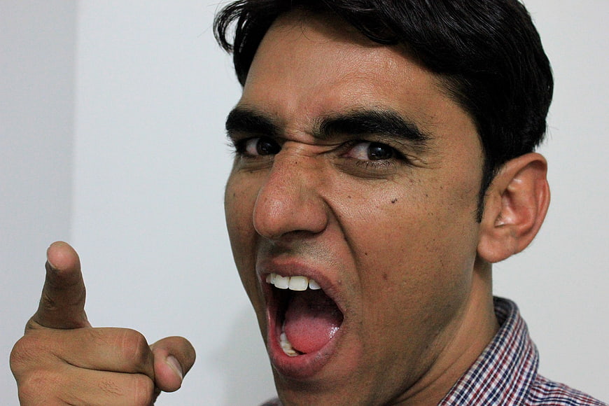 Angry man shouting and pointing finger aggressively