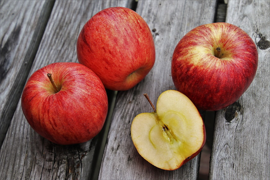Fresh Red Apples And Sliced Half On Weathered Wooden Planks