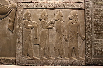 Ancient Assyrian stone relief carving with cuneiform inscription