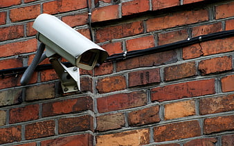 White security camera mounted on red brick wall