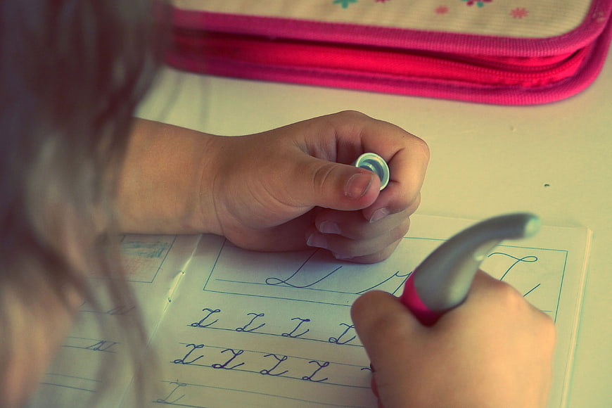 Child practicing handwriting letters in workbook
