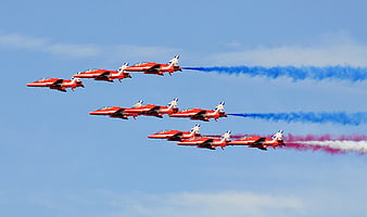 Red Jet Fighter Formation with Blue and Red Smoke Trails