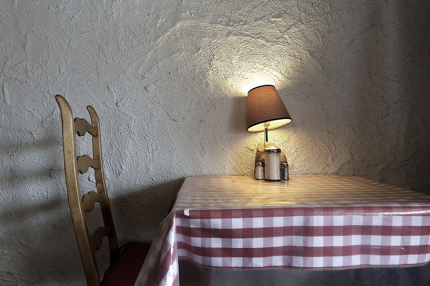 Rustic dining table with checkered cloth and lamp