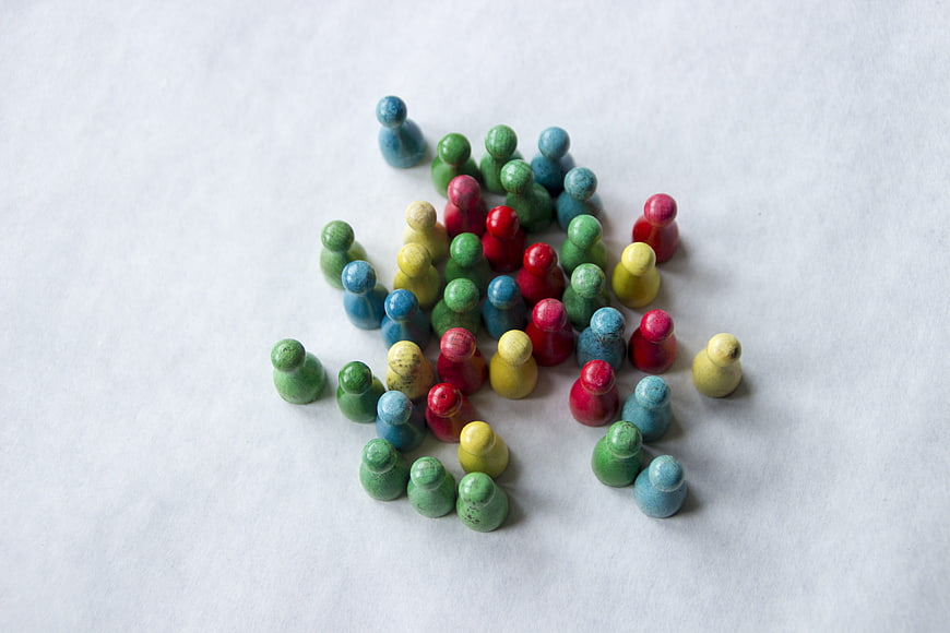 Colorful wooden game pieces on white background