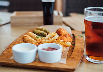 Pub snack platter with onion rings, beer, and dipping sauces