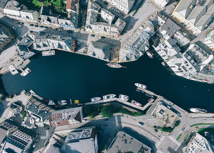 Aerial top-down view of a European city harbor with boats