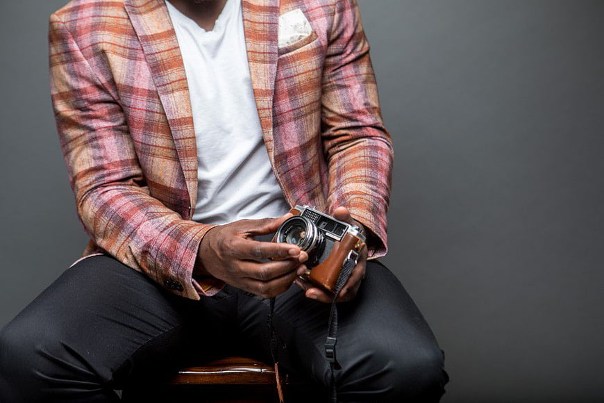 Man in Plaid Blazer Holding Vintage Camera