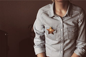 Person wearing denim shirt with sheriff badge
