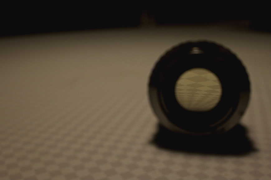 Close-up of camera lens on checkered surface