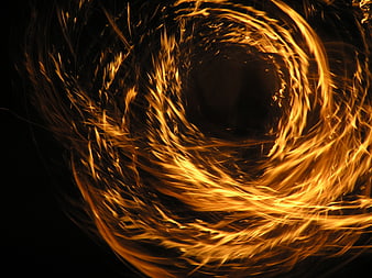 Abstract swirling fire vortex with golden sparks on black background