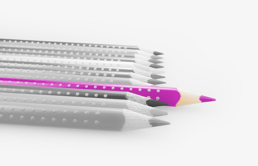 Pink Pencil Standing Out Among Gray Pencils On White Background