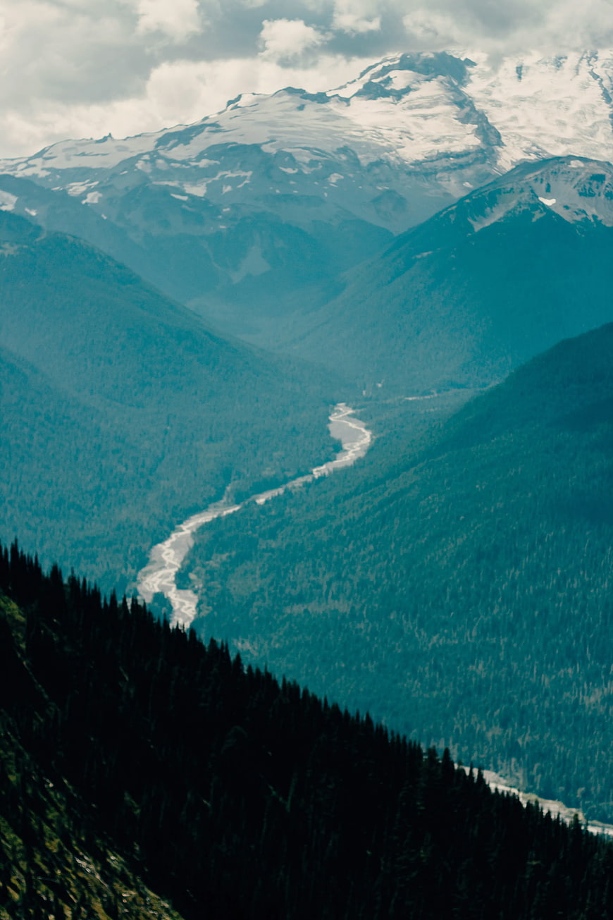 Aerial View of Winding River Through Snow-Capped Mountains