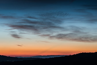 Dramatic Sunrise Sky Over Silhouetted Hills
