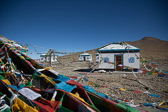 Tibetan prayer flags and white stupa in highland landscape