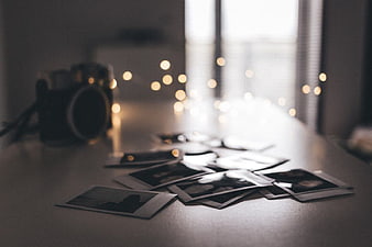 Scattered Polaroid Photos and Vintage Camera on Table