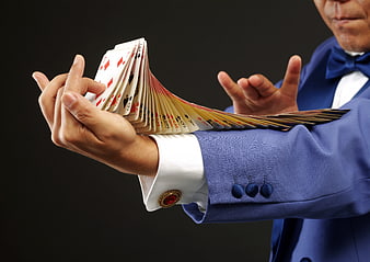 Magician in Blue Suit Fanning Playing Cards