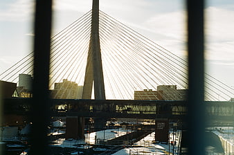 Modern cable-stayed bridge viewed through window bars in winter
