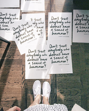 Printed quotes on wooden floor with white sneakers