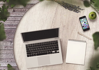 Flat lay workspace with laptop, smartphone, and notebook on wooden table