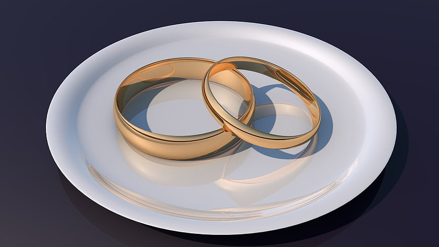 3D Render of Gold Wedding Rings on White Plate