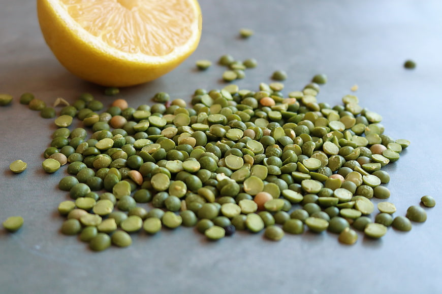 Dried Green Pea Halves and Lemon on Gray Background