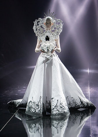 Avant-garde fashion model in white gown with black accents on runway