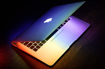 MacBook Laptop with Neon Rainbow Lighting on Dark Desk