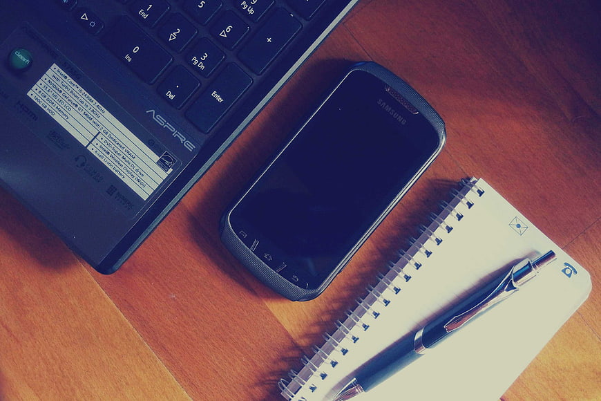 Vintage Workspace with Laptop, Smartphone, and Notepad