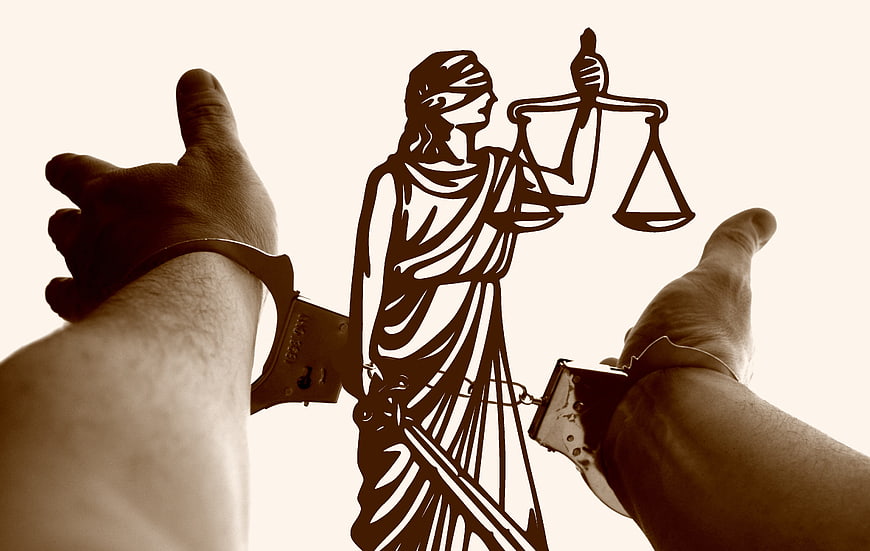 Handcuffed Hands Framing Lady Justice Silhouette
