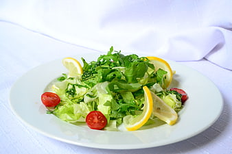 Fresh Garden Salad With Lemon Slices And Cherry Tomatoes On White Plate