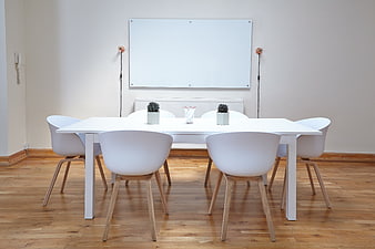 Minimalist white conference room with table and chairs