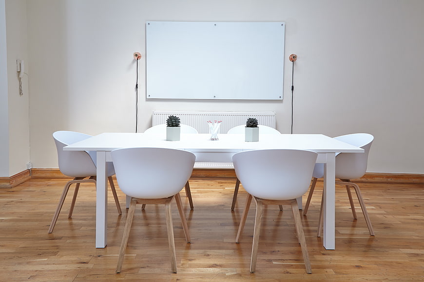 Minimalist white conference room with table and chairs
