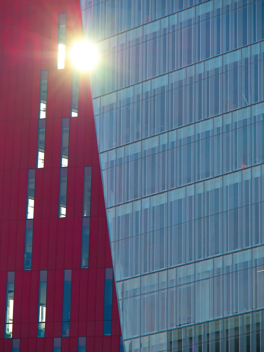 Modern Red and Blue Glass Building Facade with Sun Flare