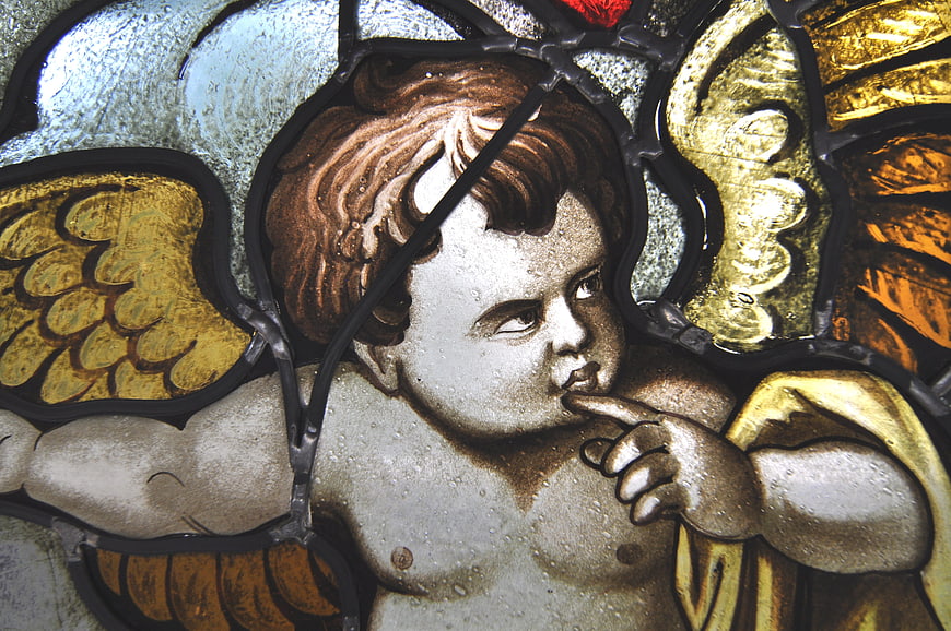 Close-up of a stained glass angel with golden wings